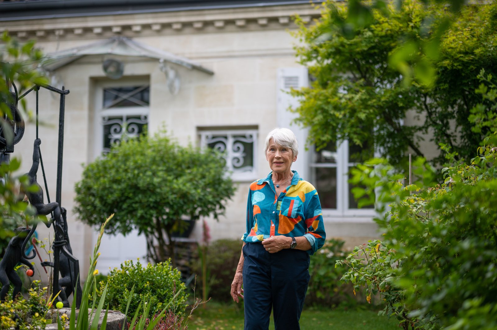 An older woman standing in her garden wearing the Ikarya Watch